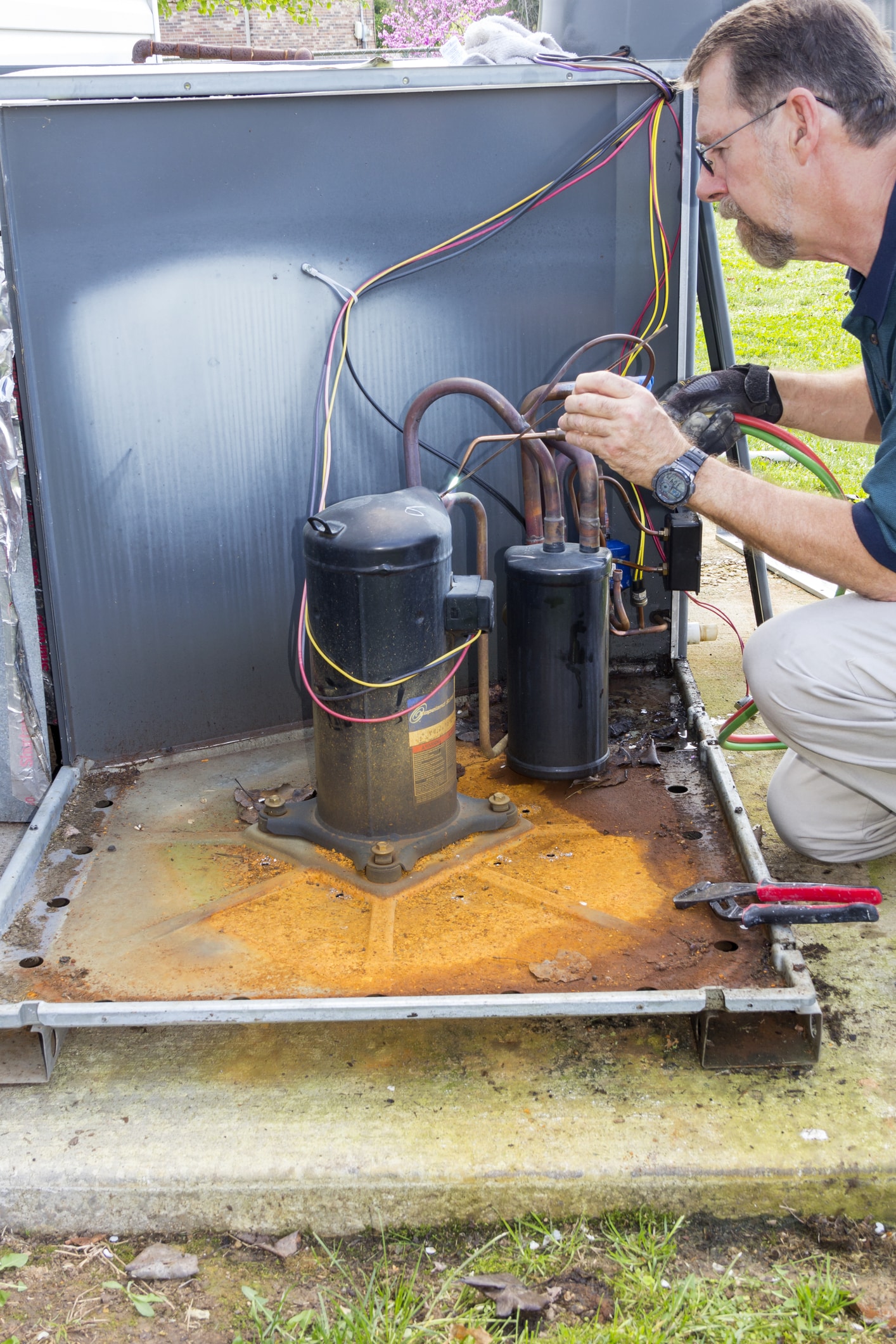Technician repairing outdoor air conditioning unit