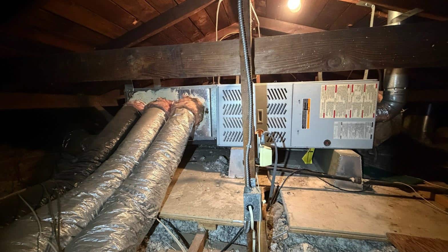 Attic air handler with insulated flex ducts and electrical conduit after complete HVAC replacement in Norwalk CA