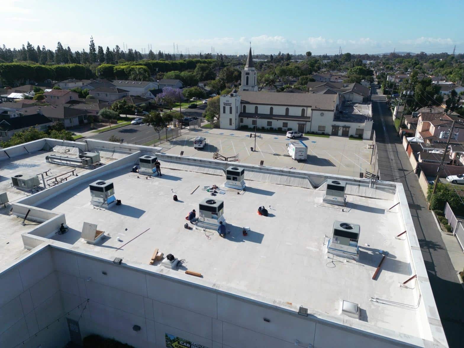 Aerial view of multiple rooftop HVAC units being installed on a commercial flat roof in Paramount CA