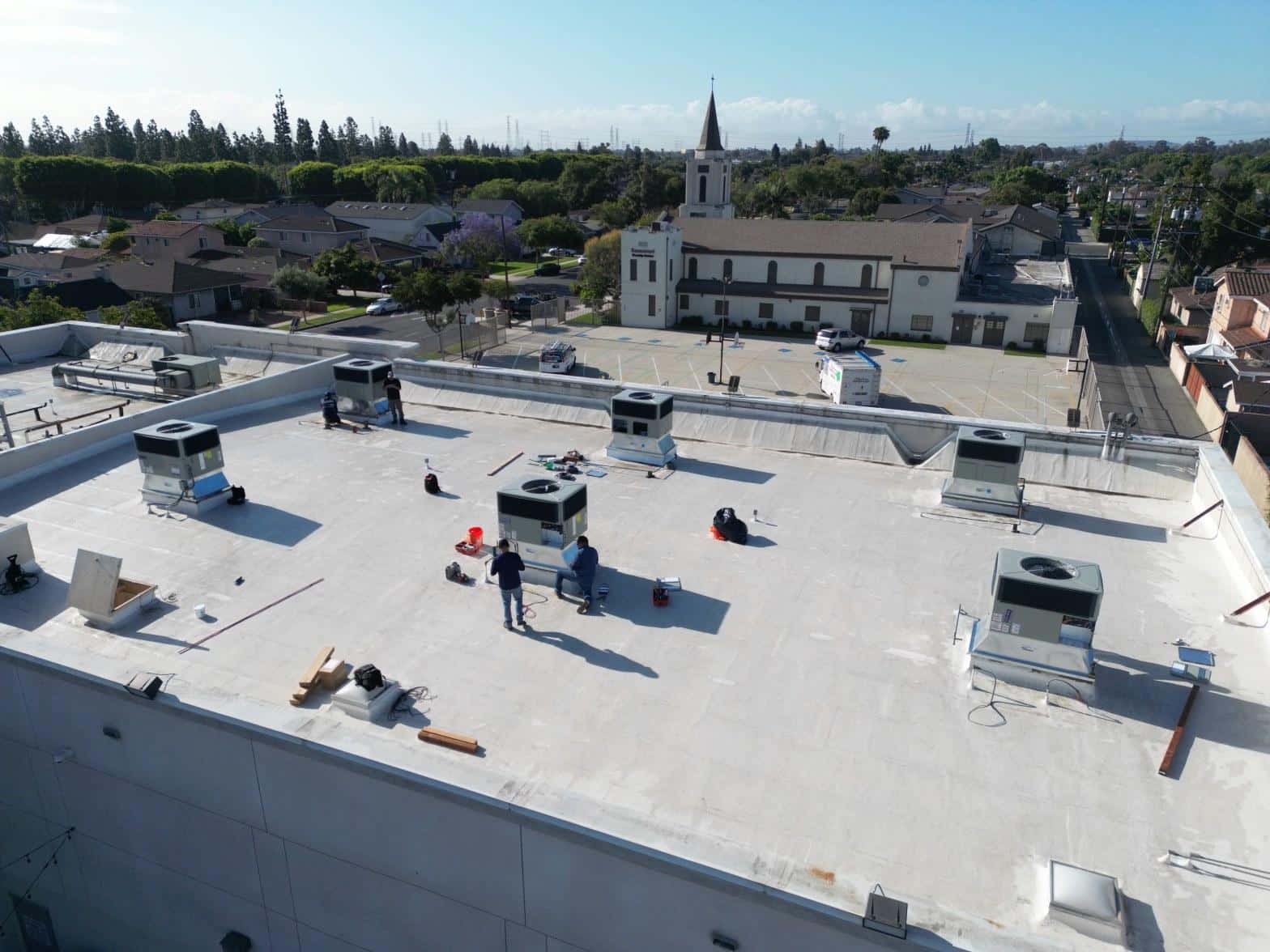 Multiple new packaged rooftop HVAC units installed and commissioning on white commercial flat roof