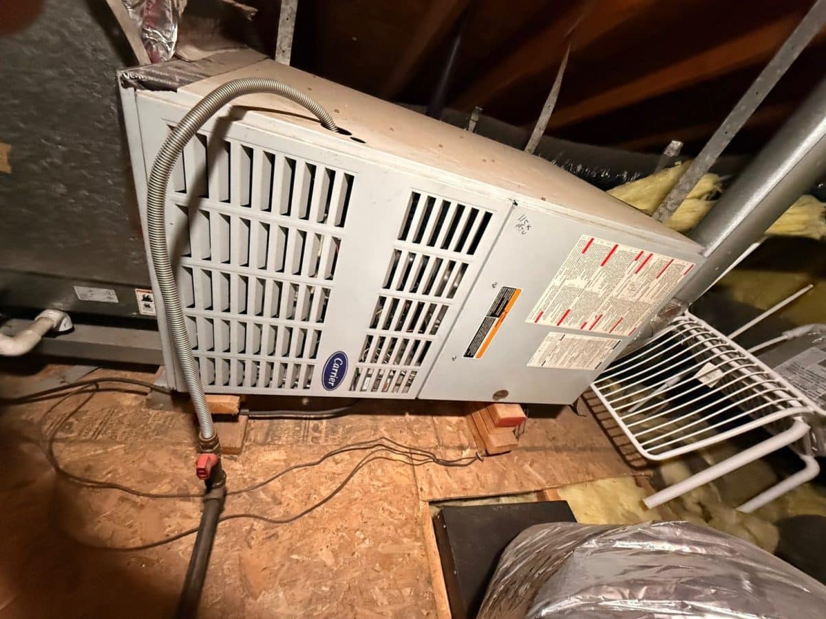 Attic air handler and furnace serviced by an HVAC technician